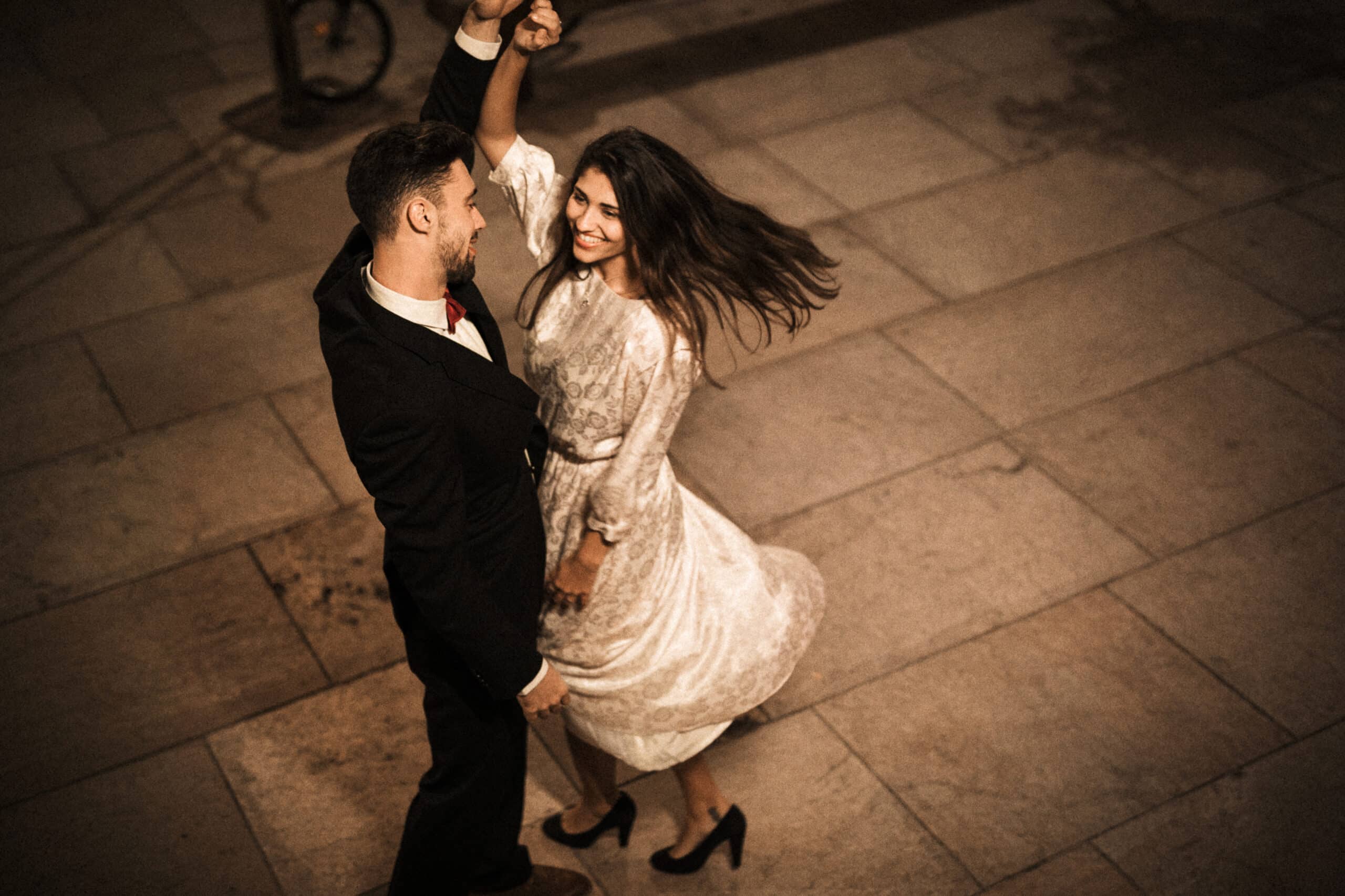 junge elegante mannholdinghand der wirbelnden attraktiven netten frau scaled